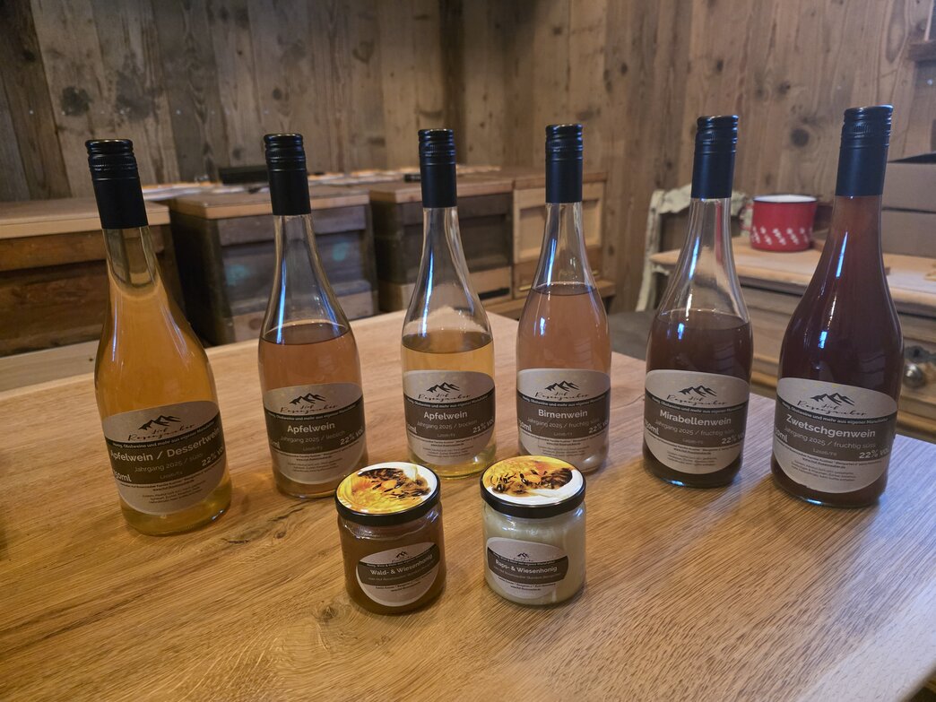 Gläser mit Honig und Flaschen Obstwein